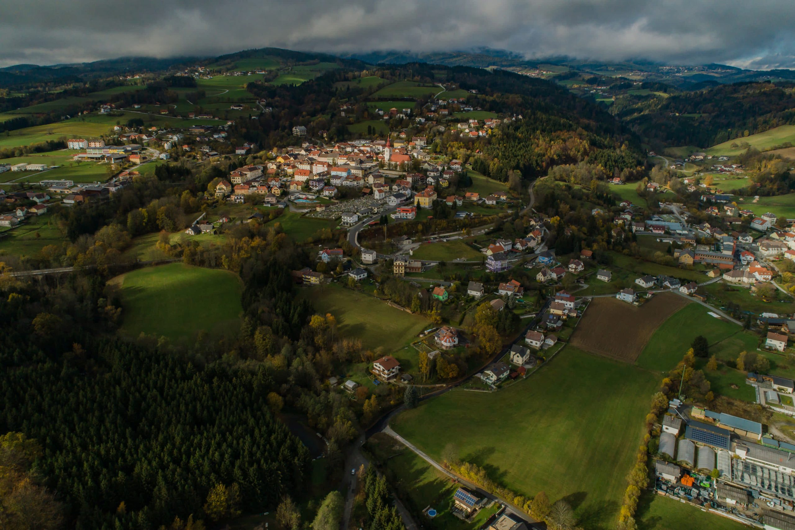 Luftaufnahme von Friedberg. Der Stadtkern liegt erhört auf einem Hügelrücken direkt neben der Marktgemeinde Pinggau