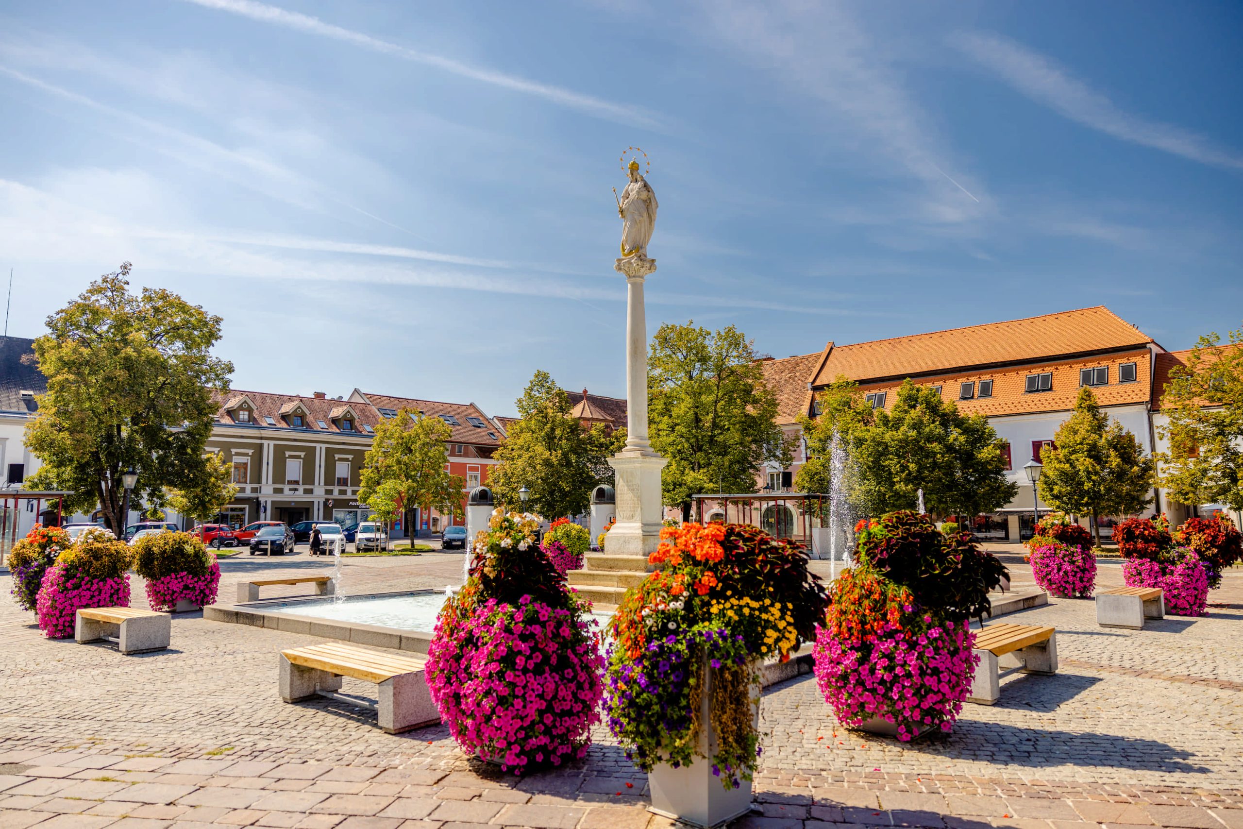 Hauptplatz in Fürstenfeld mit dem von Blumen umgebenen Marienbrunnen