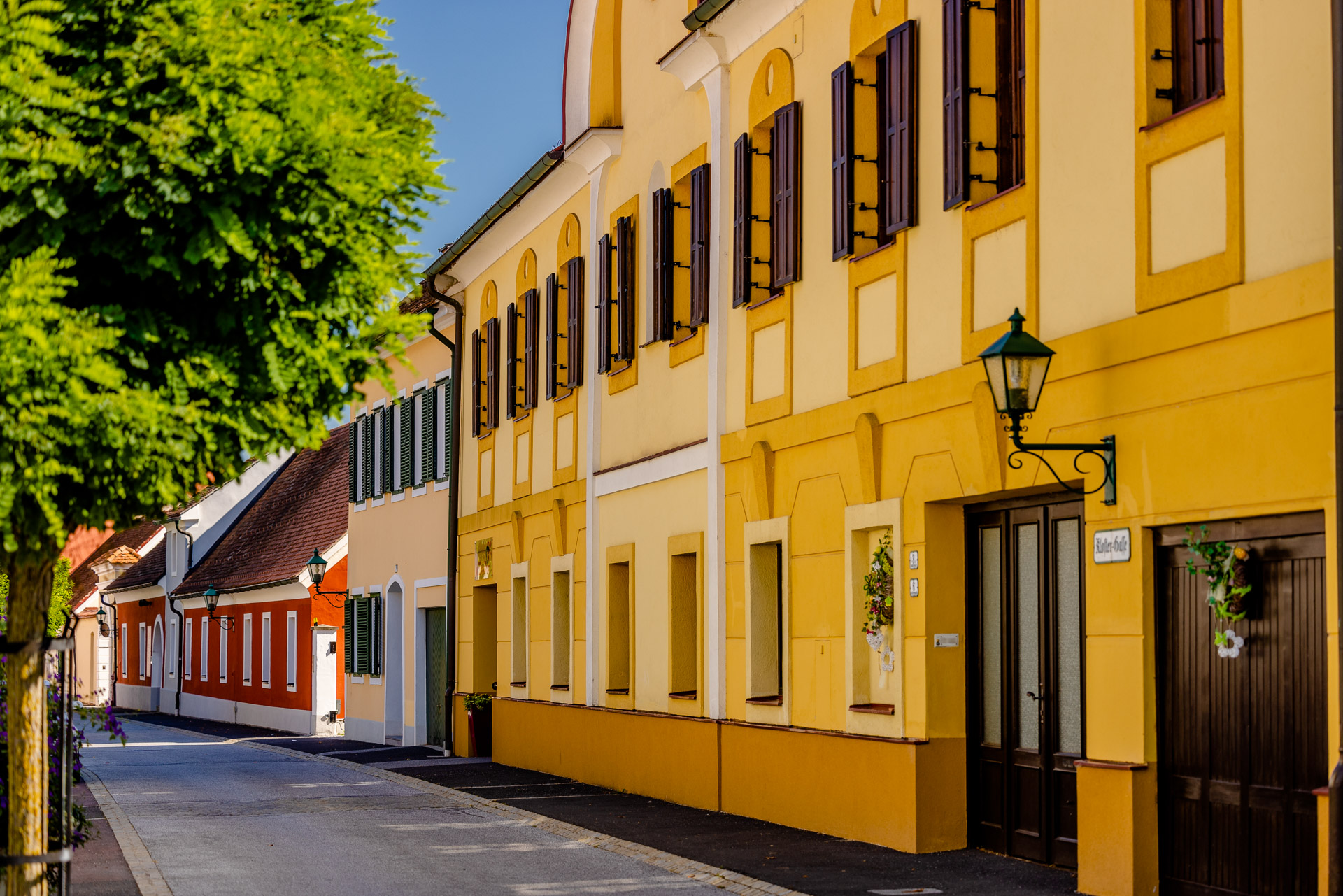Häuserzeile in der Klostergasse. Verschiedenfärbige Altbauten mit einer Höhe von ein bis zwei Geschoßen reihen sich aneinander