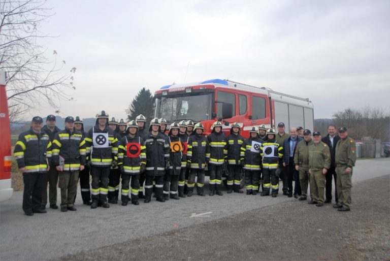 Gruppenfoto der Feuerwehr Gersdorf mit einem Löschfahrzeug im Hintergrund