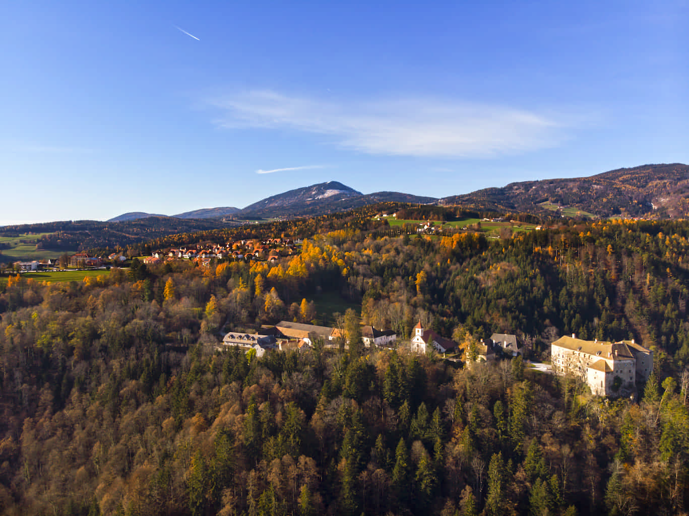 Herbstliche Aufnahme von Schloss Gutenberg mit Blick über den Ort bis zum leicht angezuckerten Schöckl