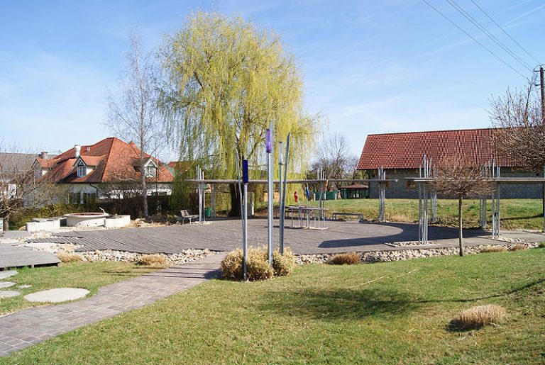 Dorfplatz in Rohr mit überdachten Sitzgelegenheiten und Begrünung