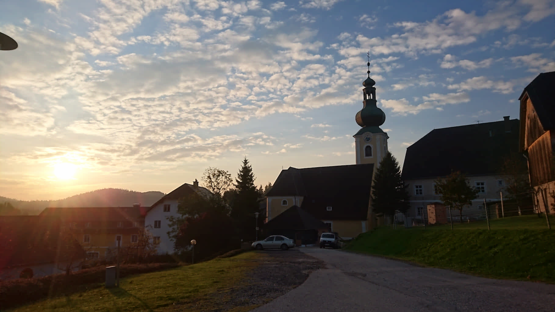 Sonnenaufgang in St. Jakob. im Zentrum des Bildes steht die Kirche umgeben von einigen alten Gebäuden