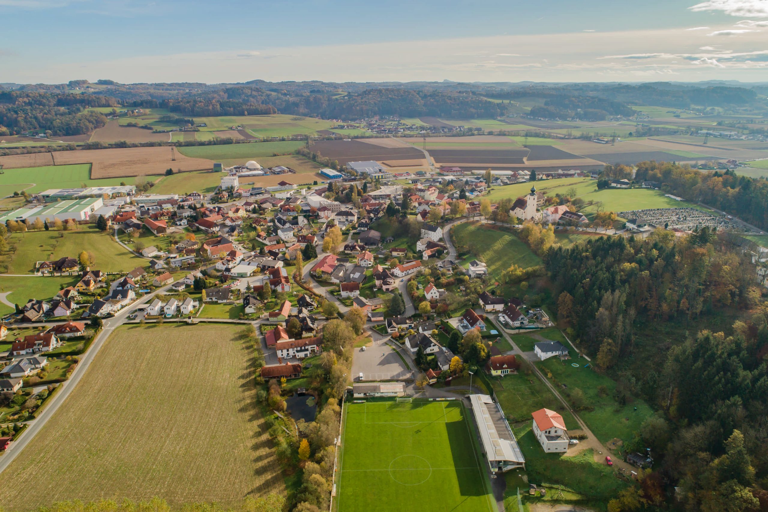 Luftaufnahme von St. Margarethen. Der Ort liegt rund um den Kirchberg, auf welchem neben der Kirche auch der Friedhof zu finden ist